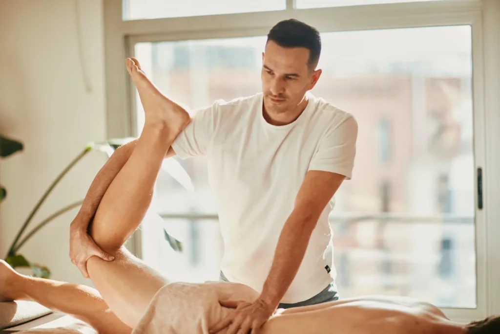 Professional Thai massage therapist performing leg stretching technique at Under Pressure massage Barcelona