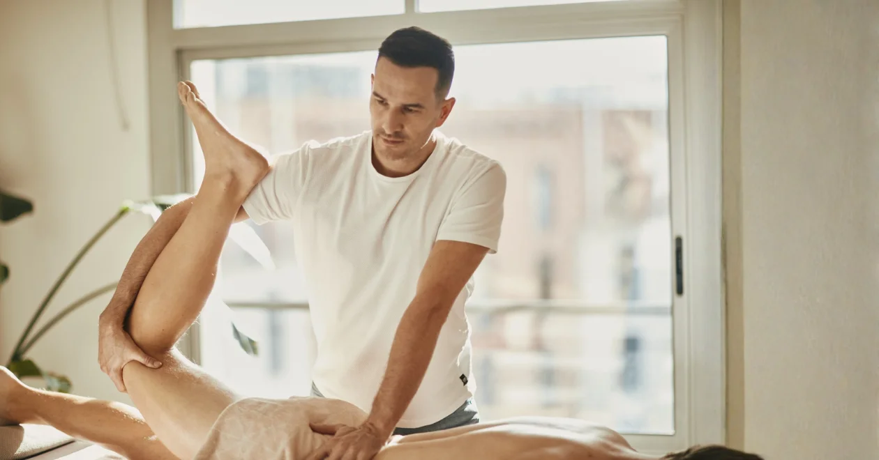 Massage therapist Julien performing deep tissue leg massage in Barcelona Eixample practice